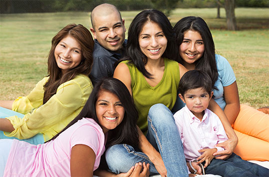 Smiling Latino family in park