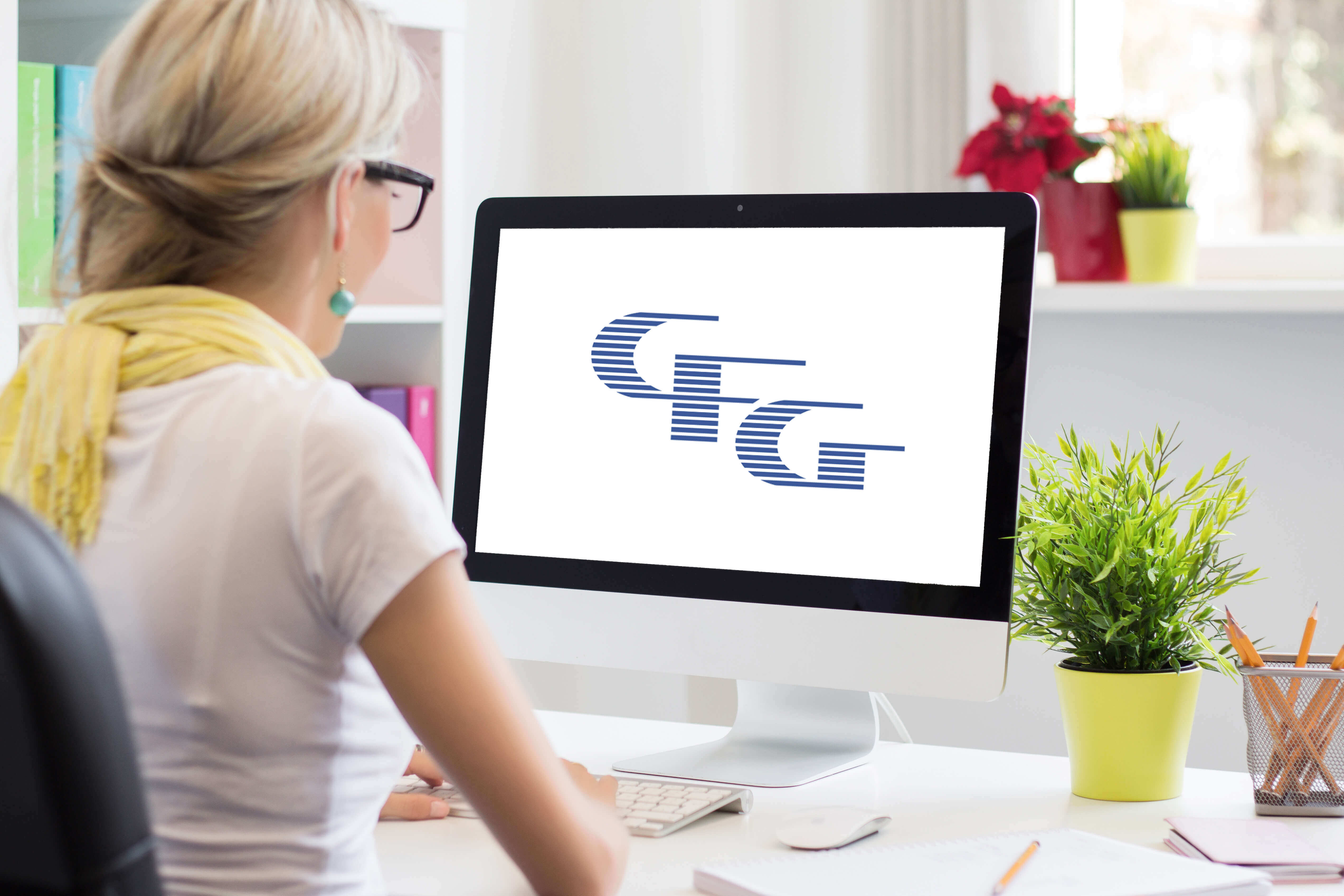 Woman at computer with CFG logo on monitor