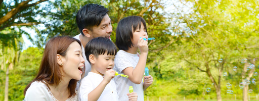 Asian parents with two children blowing bubbles